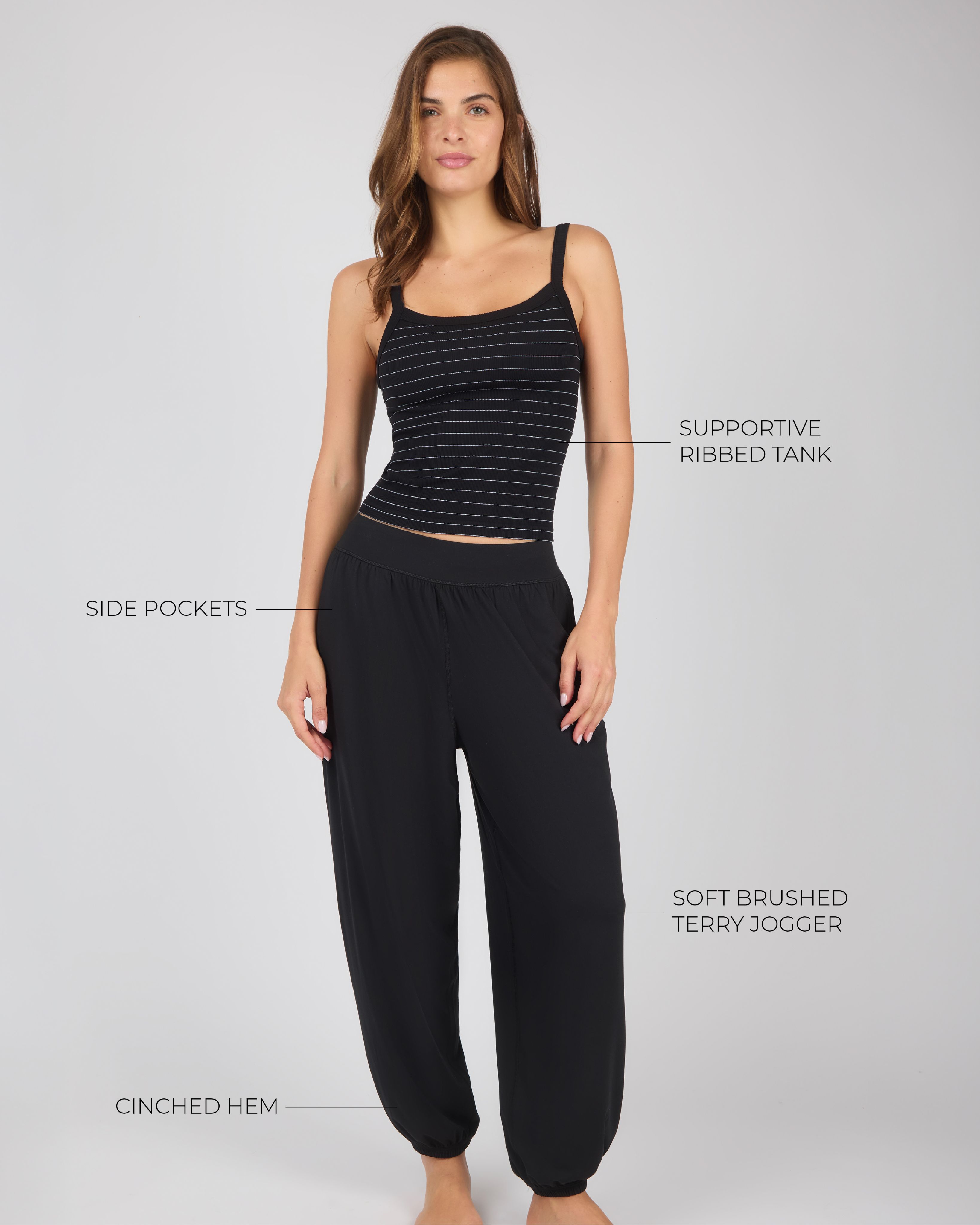 Full-length studio photo of a woman modeling a black striped tank top and black joggers, with text callouts pointing to product features.
